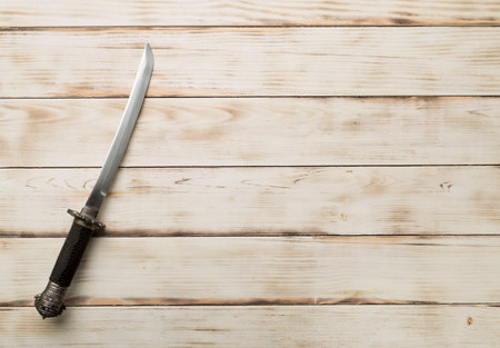 Cossack saber on wooden background, top view.
