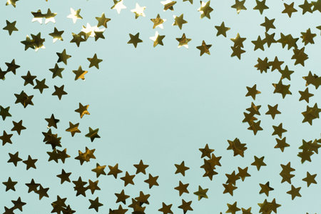 Golden confetti stars on color background, top view.の写真素材
