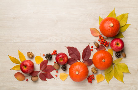 Festive autumn flat lay with pumpkins, berries and leaves on wooden background, top view.