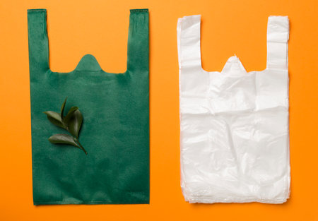 Plastic and fabric bag on color background, top view. Biodegradable products concep
