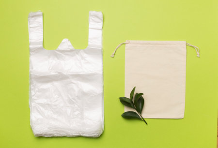 Plastic and fabric bag on color background, top view. Biodegradable products concept