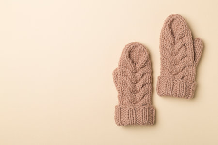Brown winter mittens on wooden background. Top view.の写真素材