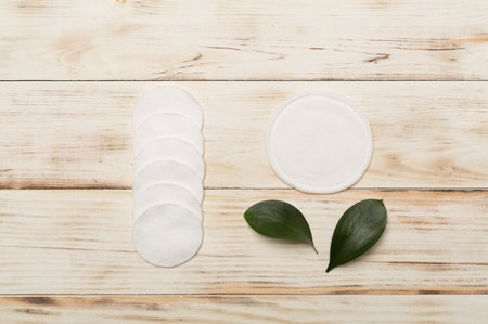 Reusable cotton pads with disposable ones on wooden background, top viewの写真素材