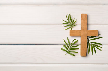 Palm branches and cross on wooden background, top view. Palm Sunday concept.の写真素材