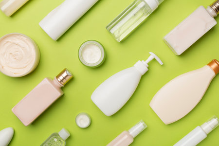 Different cosmetic bottles and container on color background, top view.の写真素材