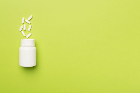White bottle with pills on color background.の写真素材