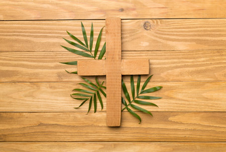 Palm branches and cross on wooden background, top view. Palm Sunday concept.の写真素材
