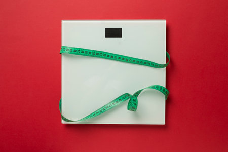 Scales and measuring tape on color background, top view. Weight loss concept.の写真素材
