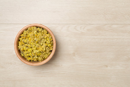 Dried immortelle herbs in bowl on wooden background, top view.の写真素材