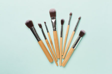Make up brushes on color background, top view