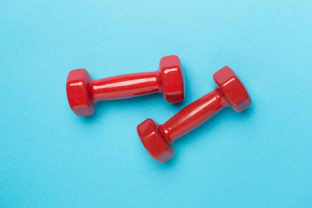 Red dumbbells on color background, top viewの写真素材