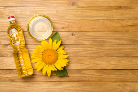 Sunflower oil and flower on wooden background, top view.の写真素材