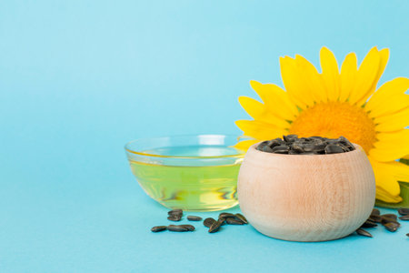 Sunflower oil, seeds and flower on color background.の写真素材