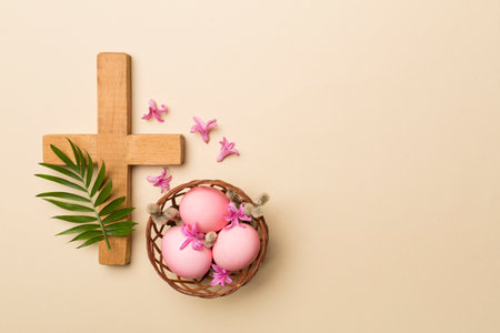 Pink Easter eggs with cross and palm leaves on color background, top viewの写真素材