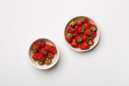 Bowl with fresh strawberries on color background, top view.の写真素材