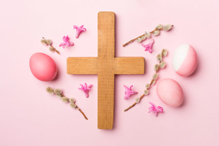 Pink Easter eggs with cross and palm leaves on color background, top viewの写真素材