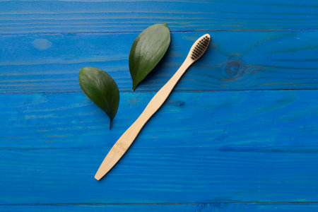 Toothbrush with green leaves wooden on background. Top viewの写真素材