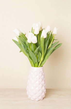 Tulip flowers in vase on wooden tableの写真素材