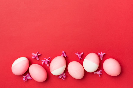 Pink Easter eggs with decor on color background, top viewの写真素材