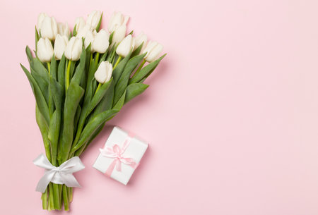 White tulip bouquet and gift box on color background, top viewの写真素材