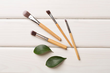 Natural biodegradable makeup brushes on wooden background, top viewの写真素材