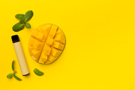Disposable electronic cigarettes with mango fruit on color background, top viewの写真素材