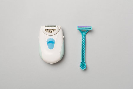 Modern epilator and razor on color background, top view.の写真素材