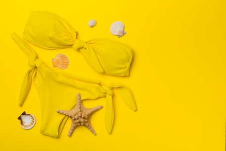Beautiful yellow bikini on color background, top view.の写真素材