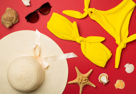 Beautiful yellow bikini and accessories on color background, top view.の写真素材