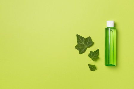 Cosmetic product with ivy extract on color background, top view.の写真素材