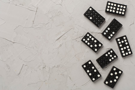 Black domino tiles on concrete background, top viewの写真素材