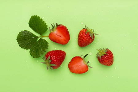 Strawberries with leaves on color background, top viewの写真素材