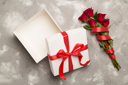 Open gift box with red roses on concrete background, top viewの写真素材