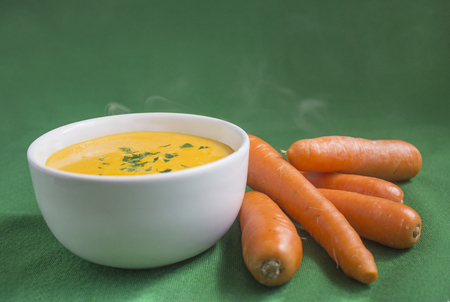 Hot carrot soup with green backgroundの写真素材