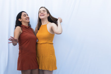 INTERRACIAL WOMEN FRIENDSHIP WITH AUTUMN COLORS DRESSESの写真素材