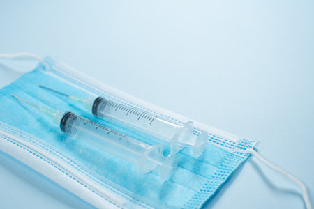 HANDS DRAWING DROPS ON BLUE BACKGROUND WITH A SYRINGEの写真素材