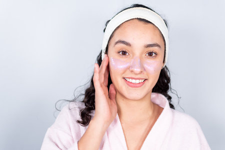 TWO LATIN AND CAUCASIAN GIRL FRIENDS DOING THEIR SKINCARE IN BATH TOWELの写真素材