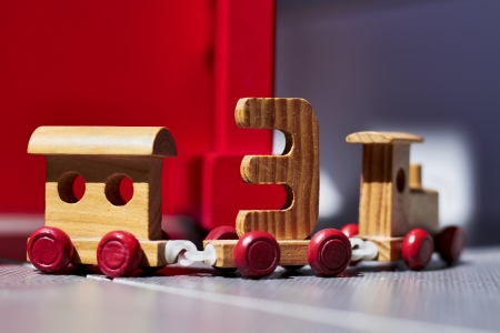 wooden  toy train on a red and gray backgroundの写真素材