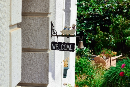 Welcome sign with bell and ducks on a summer dayの写真素材