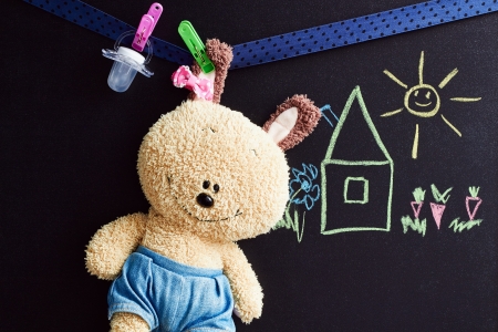 soft toy  hangs  on a rope, chalkboard with drawing   behind の写真素材