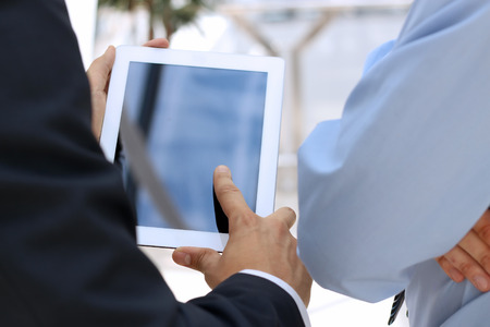 Image of two young businessmen using touchpad