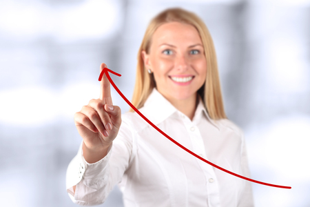 Businesswoman  touching a   virtual Graph by hand.  Blue background besideの写真素材