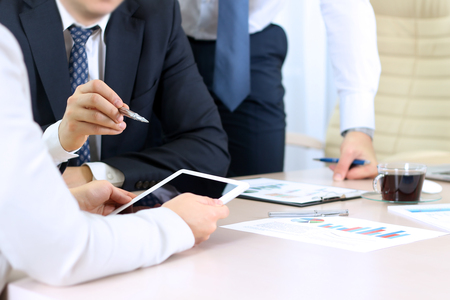 Business colleagues working and analyzing financial figures on a digital tabletの写真素材