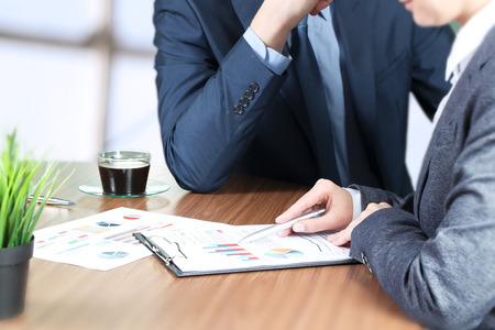 Image of business partners discussing documents and ideas at meetingの写真素材