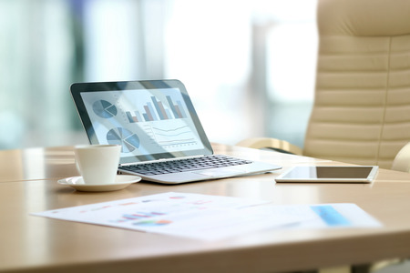 working place with laptop, digital tablet; graphs at the officeの写真素材