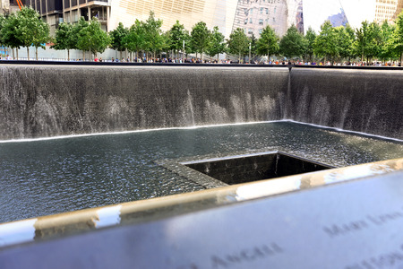New York City, USA - August 14, 2014: 9/11 Memorial at Ground Zero, Manhattan, commemorating the terrorist attack of September 11, 2001. Names of victims engraved in the bronze parapet.のeditorial素材