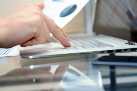 Business man working and analyzing financial figures on a graphs using laptop