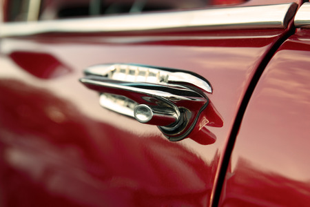 Classic retro vintage red car. Car door handle.