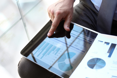 Business man working and analyzing financial figures on a graphs using laptopの写真素材