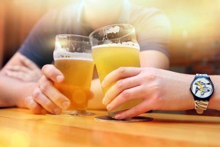 Young man and woman  drinking beer in the barの写真素材